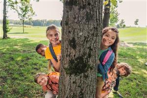 A bunch of smiling kids in a park.